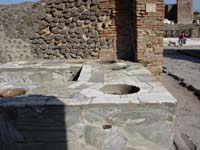 tavern counter at Pompeii with built in holes for food and drink